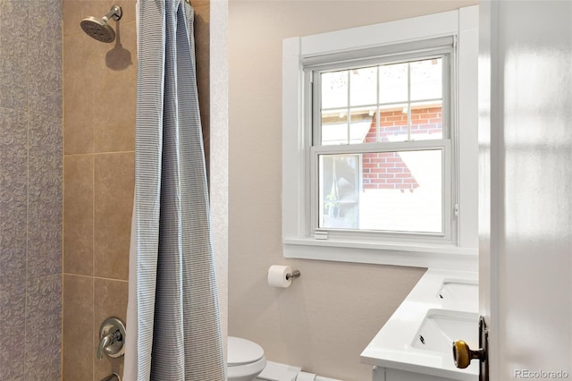 full bath with shower / tub combo, a sink, toilet, and baseboards