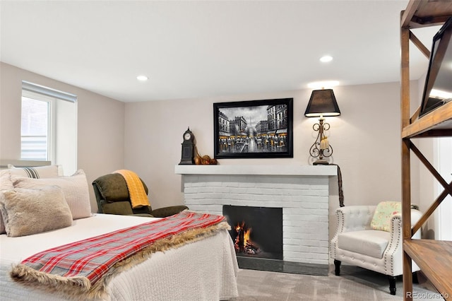 carpeted bedroom featuring a brick fireplace and recessed lighting