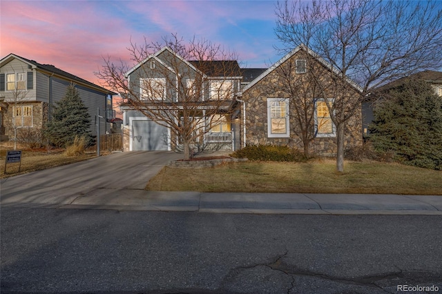 front facade featuring a garage and a yard