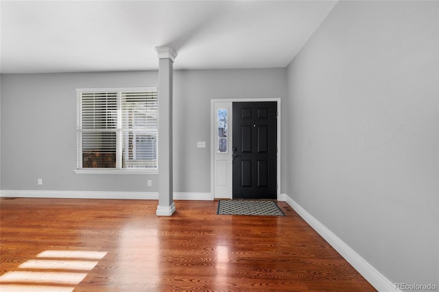 foyer entrance with ornate columns and hardwood / wood-style flooring