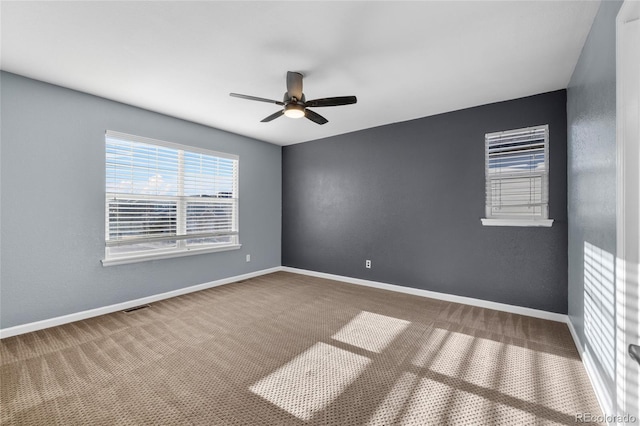 empty room featuring ceiling fan and carpet