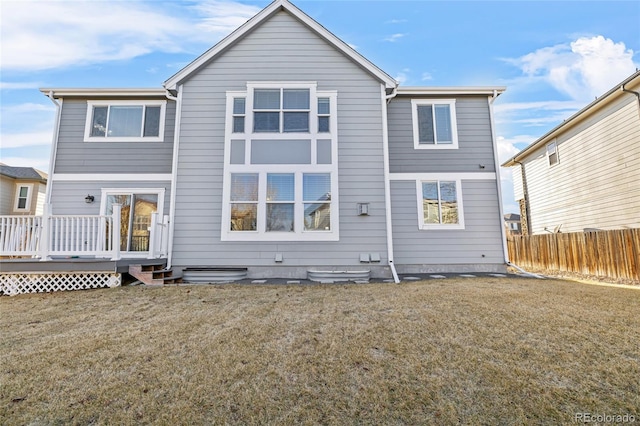 back of house featuring a wooden deck and a lawn