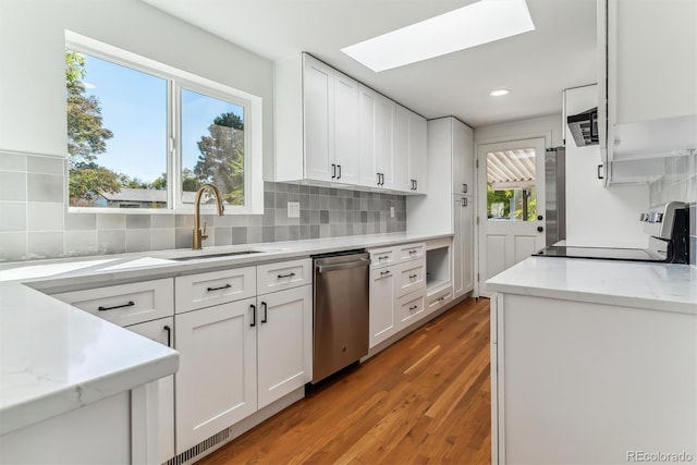 kitchen with wood-type flooring, appliances with stainless steel finishes, plenty of natural light, and white cabinetry