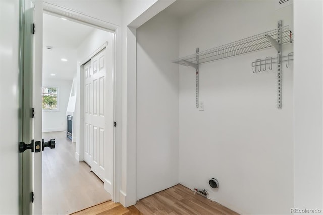 clothes washing area with wood-type flooring