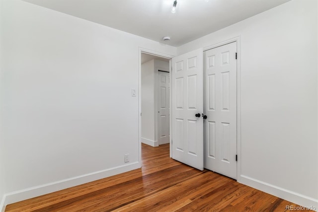 unfurnished bedroom featuring a closet and hardwood / wood-style floors