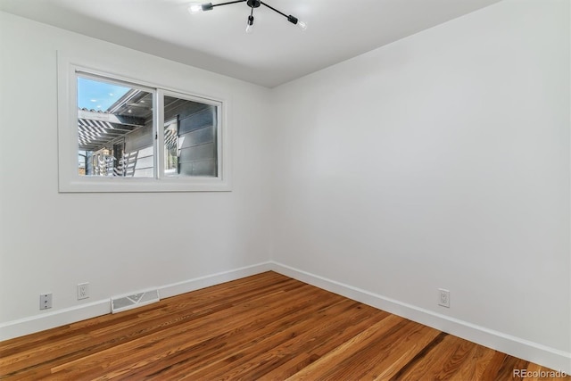 spare room featuring wood-type flooring