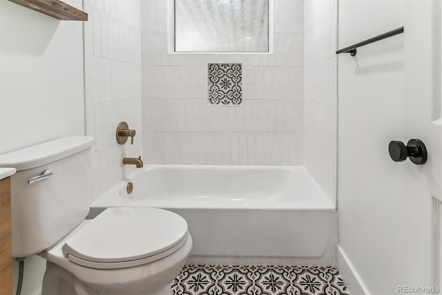 full bathroom with tiled shower / bath combo, tile patterned floors, vanity, and toilet