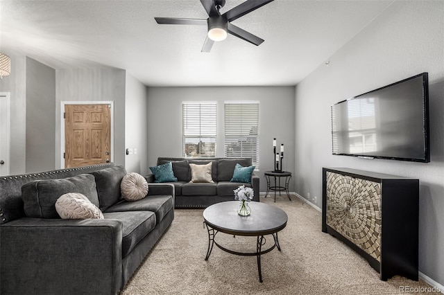 living room featuring light carpet, a textured ceiling, and ceiling fan