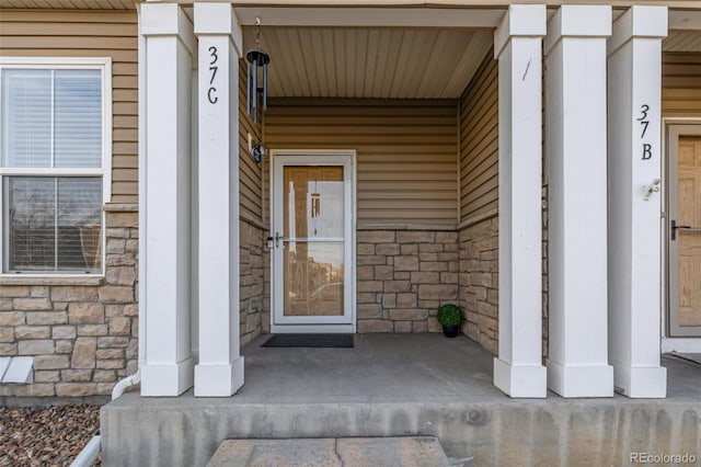 9758 Laredo St Unit 37C, Commerce City, CO 80022 - view of exterior entry featuring a porch and stone siding