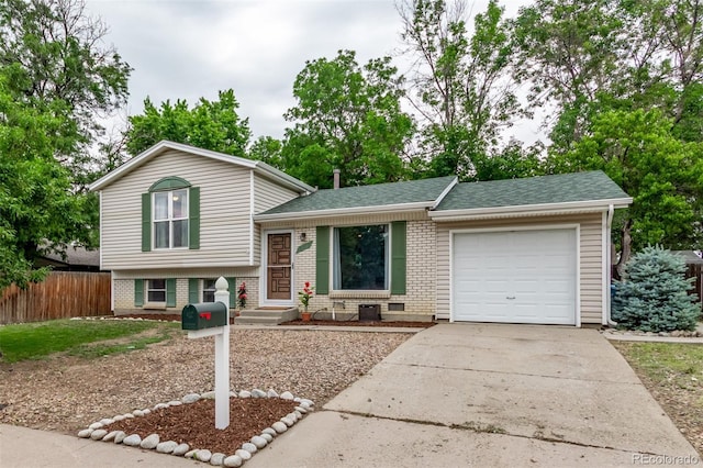 2212 S Naples Way, Aurora, CO 80013 - tri-level home featuring a garage, concrete driveway, brick siding, and roof with shingles