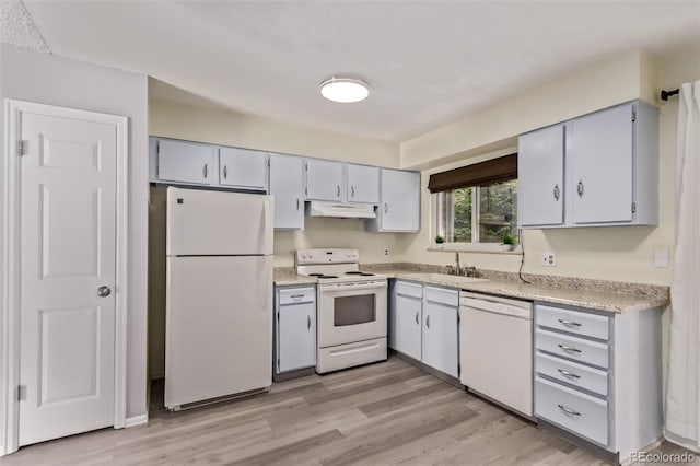 2212 S Naples Way, Aurora, CO 80013 - kitchen with white appliances, under cabinet range hood, light countertops, and light wood finished floors