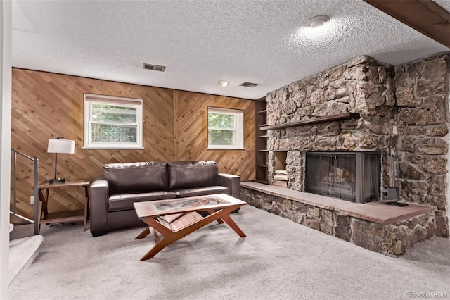 2212 S Naples Way, Aurora, CO 80013 - carpeted living area with plenty of natural light, a textured ceiling, a fireplace, and wood walls