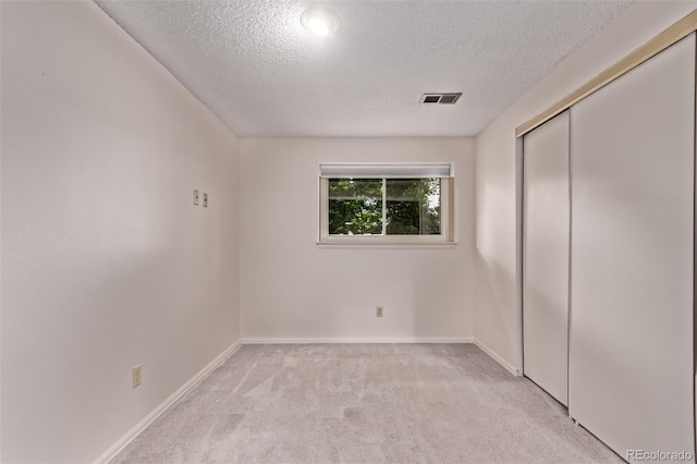 2212 S Naples Way, Aurora, CO 80013 - unfurnished bedroom with a textured ceiling, light colored carpet, and a closet