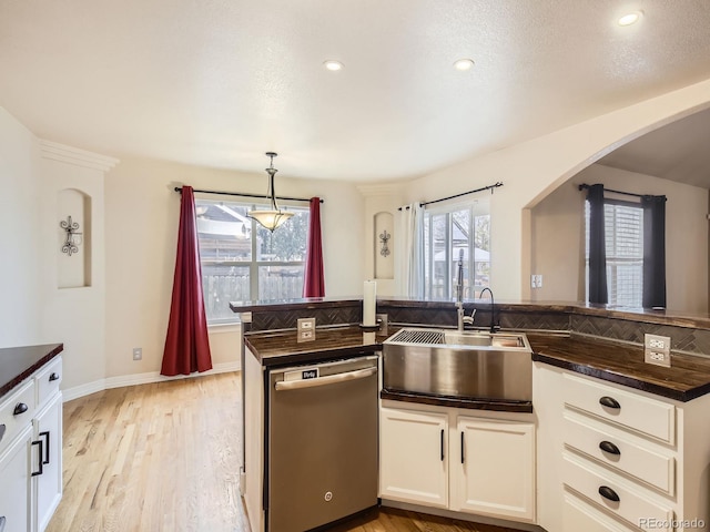 kitchen featuring white cabinetry, dishwasher, sink, hanging light fixtures, and light hardwood / wood-style floors