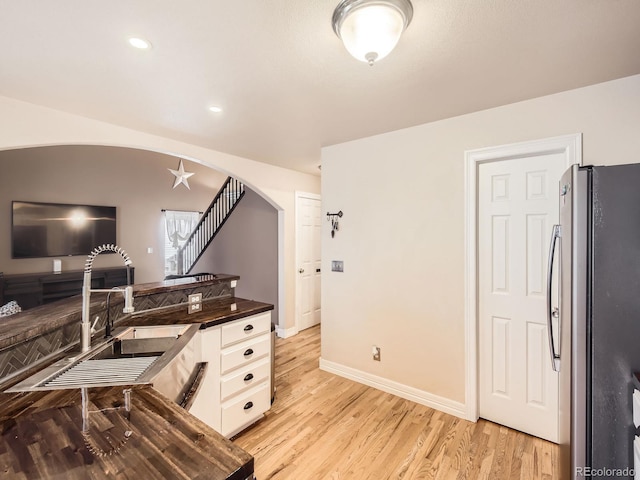 home office with sink and light hardwood / wood-style flooring