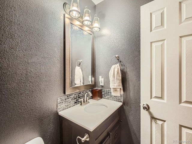 bathroom featuring vanity and backsplash