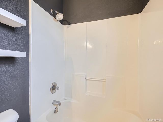 bathroom featuring bathing tub / shower combination and toilet