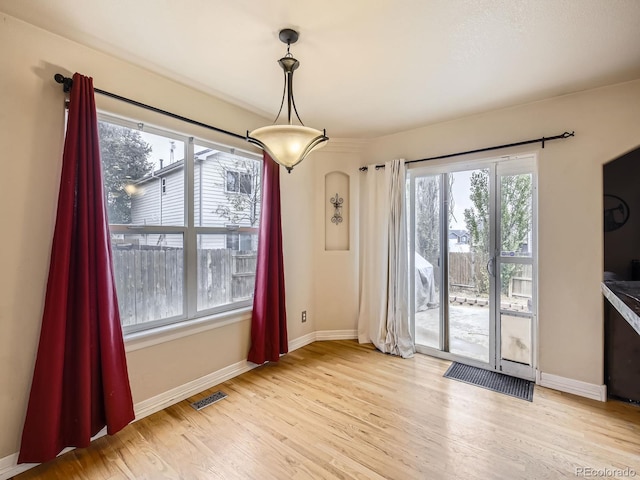 unfurnished dining area with plenty of natural light and light hardwood / wood-style flooring