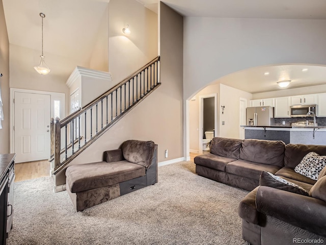 living room featuring high vaulted ceiling and light carpet