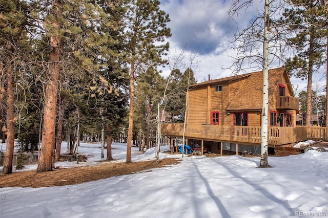 snow covered house with a wooden deck