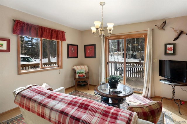 living area featuring baseboards, wood finished floors, and a notable chandelier