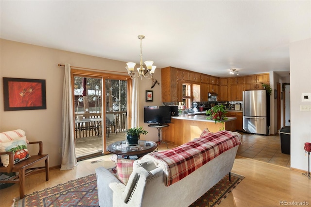 living room featuring a chandelier, visible vents, and light wood finished floors