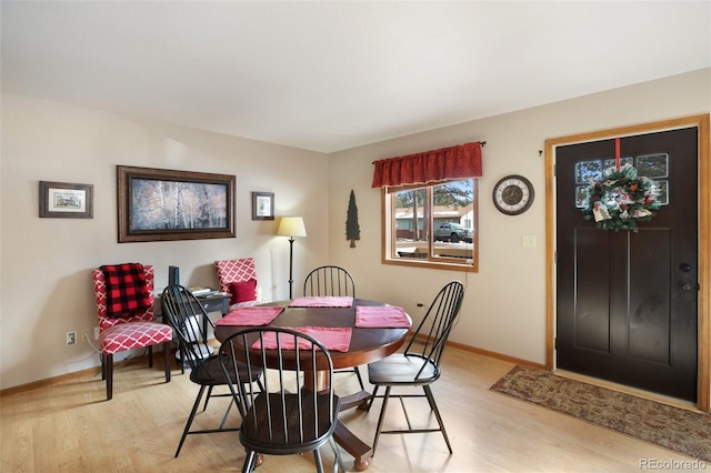 dining area featuring light wood finished floors and baseboards