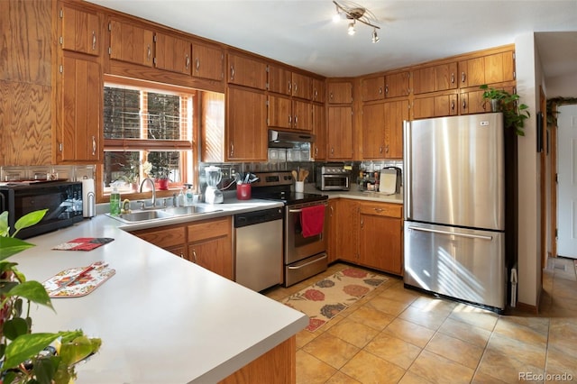 kitchen with sink, backsplash, light tile patterned floors, and appliances with stainless steel finishes