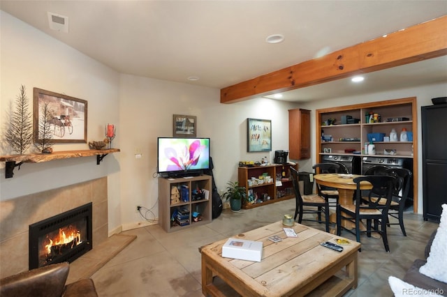 living area featuring recessed lighting, a fireplace, washer and clothes dryer, visible vents, and beamed ceiling