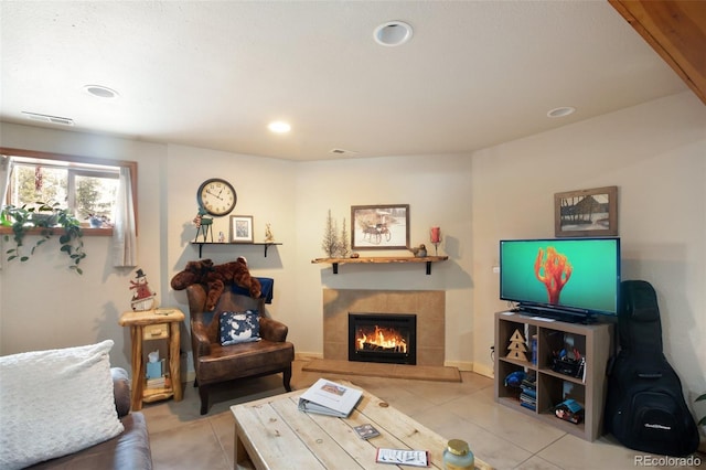 living area with tile patterned flooring, a tile fireplace, recessed lighting, visible vents, and baseboards