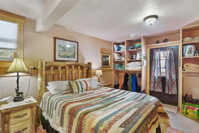 bedroom featuring a textured ceiling and light tile patterned floors