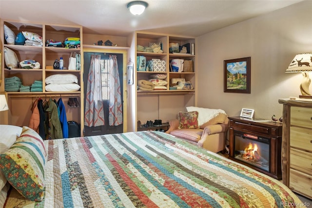 bedroom featuring a glass covered fireplace