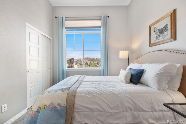 carpeted bedroom featuring baseboards, a closet, and multiple windows