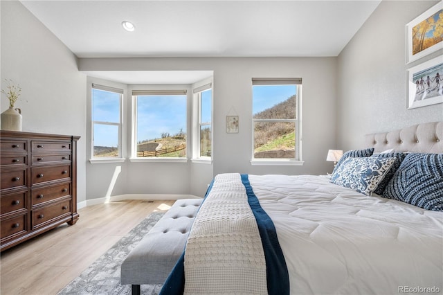 bedroom with light wood-style floors, baseboards, and recessed lighting