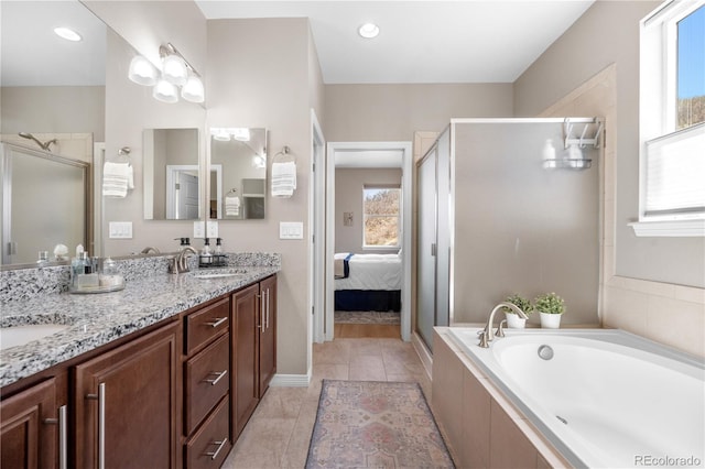 ensuite bathroom with double vanity, a garden tub, a stall shower, a sink, and ensuite bathroom