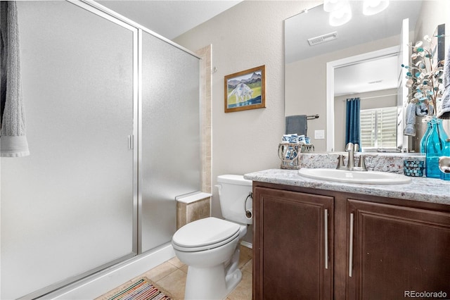 bathroom featuring vanity, toilet, tile patterned floors, a shower stall, and visible vents