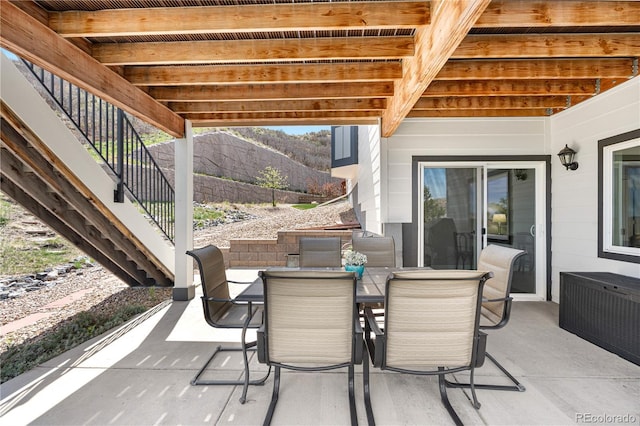 view of patio / terrace with outdoor dining area, a mountain view, and stairs