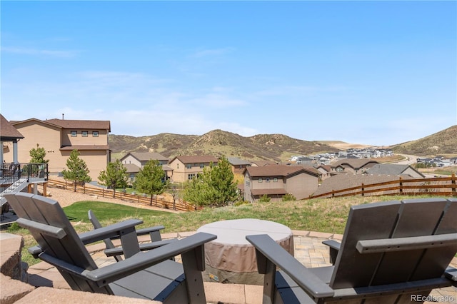 view of patio featuring fence, a mountain view, and a residential view