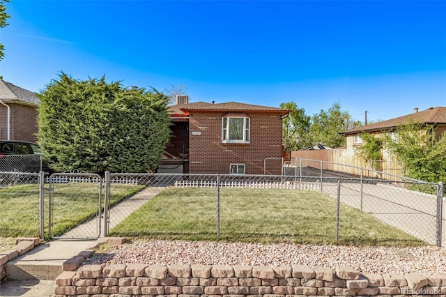 view of front of home featuring brick siding, fence, a gate, and a front lawn