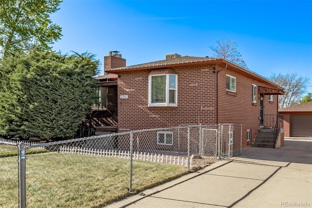 view of side of home with fence, a chimney, brick siding, a lawn, and a detached garage