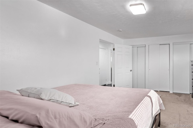 bedroom featuring carpet floors and two closets
