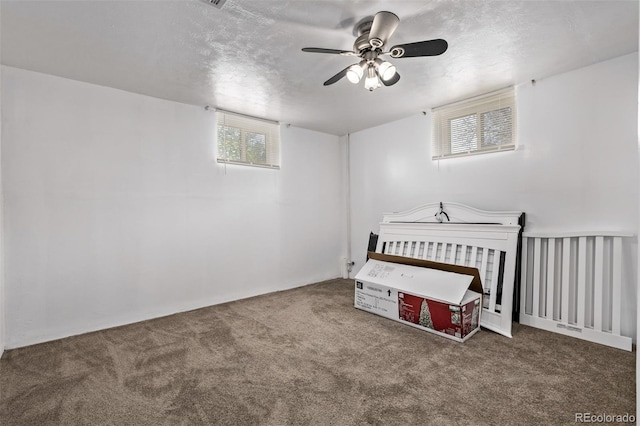 carpeted bedroom with a ceiling fan and a textured ceiling