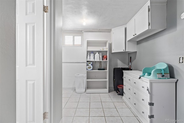 kitchen featuring white cabinets, a textured ceiling, and light tile patterned floors
