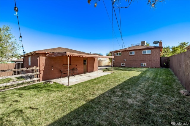 rear view of property featuring a fenced backyard, a patio, a lawn, and central AC