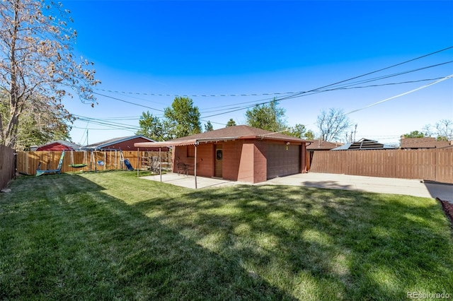 rear view of house featuring a detached garage, a fenced backyard, a playground, a patio, and a yard