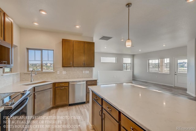 881 W 128th Pl, Westminster, CO 80234 - kitchen with appliances with stainless steel finishes, healthy amount of natural light, light wood-type flooring, tasteful backsplash, and recessed lighting