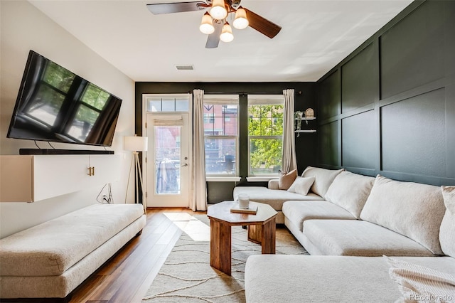 living room featuring hardwood / wood-style floors and ceiling fan