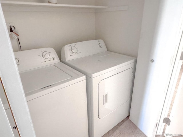 clothes washing area featuring light carpet and washing machine and dryer