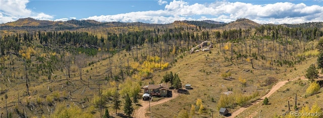 birds eye view of property featuring a view of trees and a mountain view