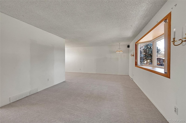 spare room featuring carpet floors and a textured ceiling